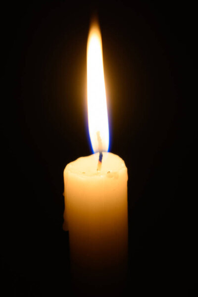Burning out wax candle on a dark background