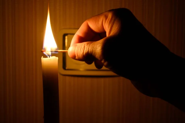 Eine Brennende Kerze Auf Dem Hintergrund Einer Steckdose Ohne Strom — Stockfoto