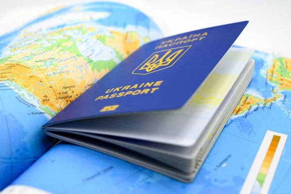 国家特写地图背景上带有三叉戟的蓝色乌克兰语生物鉴别护照 — 图库照片
