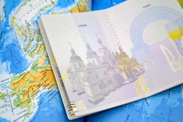 教会のイメージとウクライナの市民権の生体パスポートを開きました 世界地図のクローズアップを背景に — ストック写真