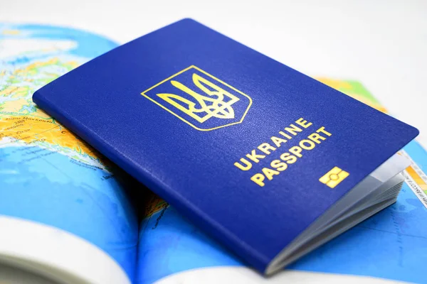 青い色のウクライナの生体パスポート国の地図の背景にトライデントがあるクローズアップ — ストック写真