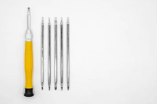 universal screwdriver for small jewelry repairs with a set of interchangeable bits on a white background close-up top view