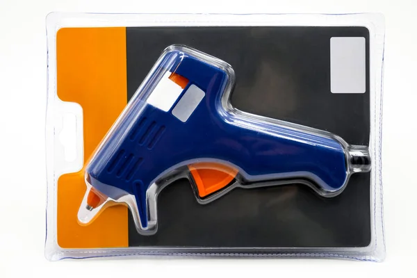 blue glue gun with plastic sticks on a white background. Close-up. Empty space for text. Top view