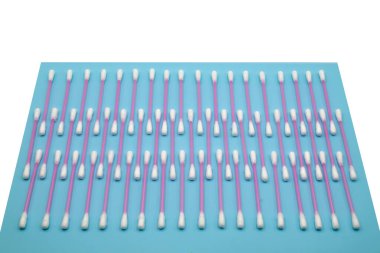 Pamuklu çubuk Tupfer. Ev hijyeni ve kulak temizliği için steril bir çubuk. Mavi arka planda biyolojik materyaller toplamak için.