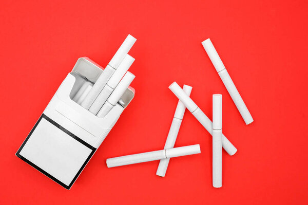 открытая пачка сигарет на красном фоне крупным планом, вид сверху, мир без курения день