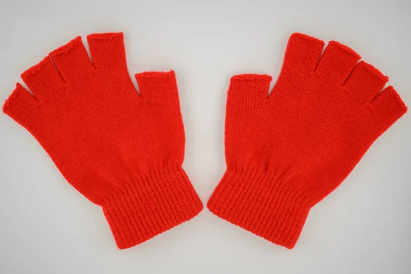 warm knitted red mittens on a white background close-up top view