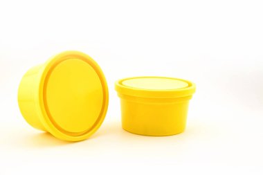 Yiyecek depolamak için kapağı olan iki sarı plastik kap, beyaz arka planda yakın plan görüntüsü.