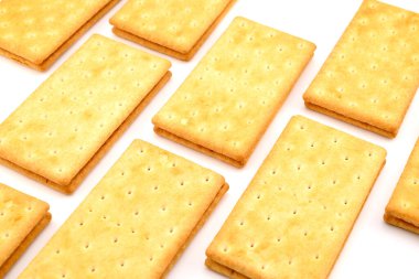 Beyaz arka planda bir sürü lezzetli tuzlu kraker.