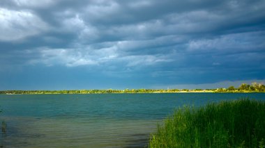 Mavi göl ya da deniz önce güçlü bir fırtına ufukta kara bulutlar asılı, gün batımından önce, dekorasyon ve tasarım için duvar kağıdı