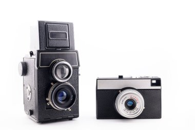 İki siyah retro film kamerası, 135 mm ve orta format, yakın plan, beyaz arka plan, yan görüş