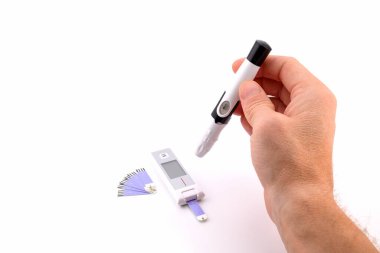 Kan şekeri seviyesini ölçmek için insan eliyle sunucu, yakın plan, yan görüş, beyaz üzerine izole edilmiş.
