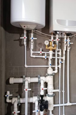 Yeni gaz ve elektrik kazanı, plastik boruları, vanaları ve diğer ekipmanları olan ısıtma sistemi kazan dairesinde, ısıtma sistemi, modern bir ev.