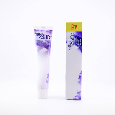 Plastik tüpte nane aromalı hijyenik florür diş macunu, yakınlarda karton ambalaj, ağız ve diş sağlığı için diş ürünleri konsepti, yakın plan, beyaz üzerine izole edilmiş.