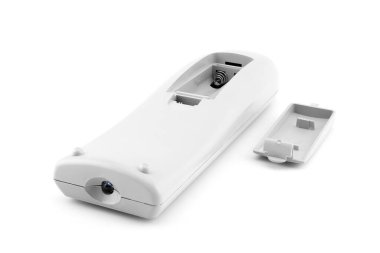 Uzaktan kumanda, batarya bölümünden görüntü, arka kapağı kaldırılmış ve yakınlarda yatıyor, ev eğlence sistemlerini ve TV 'yi kontrol etmek için tasarlanmış, beyaz arka planda yakın plan.