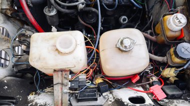 Araba hizmet merkezindeki eski bir otomobil motorunun üst görüntüsü, retro arabaların onarımı ve bakımı, sıvılar için genişleme tanklarının kapatılması, yağ ve teknik sıvılarla planlanan araba bakımı değişiklikleri