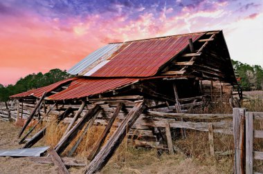 An Old Abandoned Run Down Barn in a Field at Sunset
