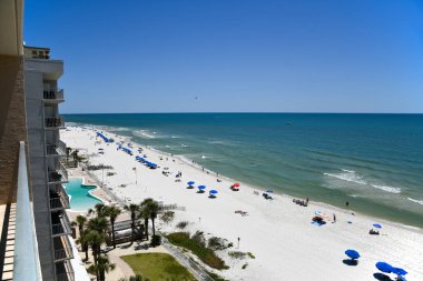 GULF SHORES, AL / USA - 2 Mayıs 2023: İnsanlar Meksika Körfezi 'ndeki Gulf Shores Plajı' nda güneşli güzel bir günün tadını çıkarıyorlar.    