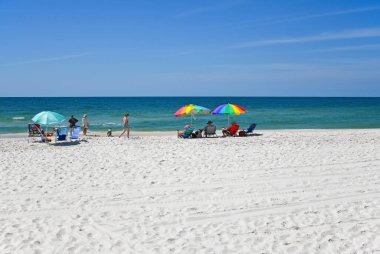 GULF SHORES, AL / USA - 3 Mayıs 2023: İnsanlar Meksika Körfezi 'ndeki Gulf Shores Plajı' nda güneşli güzel bir günün tadını çıkarıyorlar.      