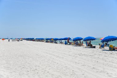 GULF SHORES, AL / USA - 3 Mayıs 2023: İnsanlar Meksika Körfezi 'ndeki Gulf Shores Plajı' nda güneşli güzel bir günün tadını çıkarıyorlar.