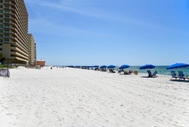 GULF SHORES, AL / USA - 3 Mayıs 2023: İnsanlar Meksika Körfezi 'ndeki Gulf Shores Plajı' nda güneşli güzel bir günün tadını çıkarıyorlar.     