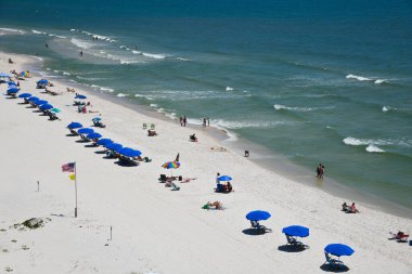 GULF SHORES, AL / USA - 2 Mayıs 2023: İnsanlar Meksika Körfezi 'ndeki Gulf Shores Plajı' nda güneşli güzel bir günün tadını çıkarıyorlar.    