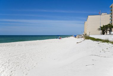 GULF SHORES, AL / USA - 3 Mayıs 2023: İnsanlar Meksika Körfezi 'ndeki Gulf Shores Plajı' nda güneşli güzel bir günün tadını çıkarıyorlar.     