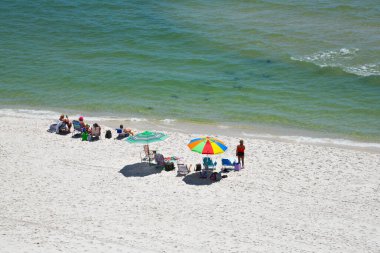 GULF SHORES, AL / USA - 3 Mayıs 2023: İnsanlar Meksika Körfezi 'ndeki Gulf Shores Plajı' nda güneşli güzel bir günün tadını çıkarıyorlar.     
