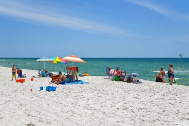 GULF SHORES, AL / USA - 4 Mayıs 2023: İnsanlar Meksika Körfezi 'ndeki Gulf Shores Beach' te güneşli güzel bir günün tadını çıkarıyorlar     