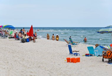 GULF SHORES, AL / USA - 4 Mayıs 2023: İnsanlar Meksika Körfezi 'ndeki Gulf Shores Beach' te güneşli güzel bir günün tadını çıkarıyorlar