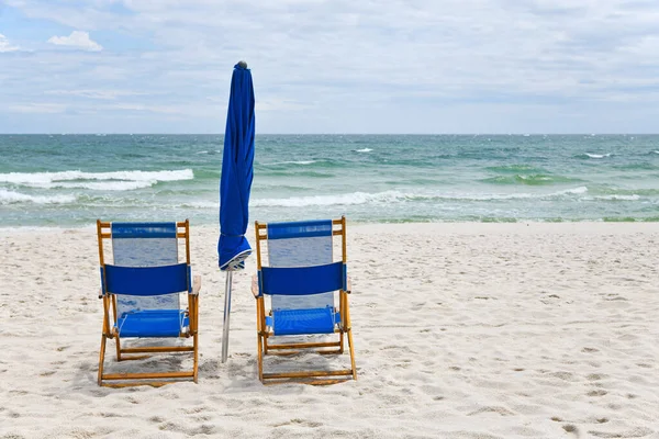 白沙滩上有雨伞的蓝色海滩椅子 — 图库照片
