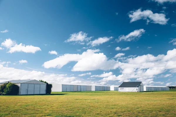 stock image Steel barn on a farm with cloudy blue sky.