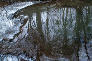Kışın ormanda küçük bir derede akan su..