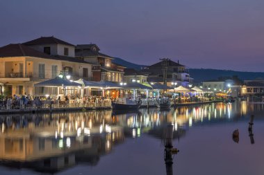 LEFKADA TOWN, GREECE - 21 AĞUSTOS 2023: Yunanistan 'ın İyon Adaları' nın Lefkada kentinin kostal caddesinin şaşırtıcı günbatımı manzarası