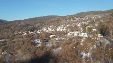 Bulgaristan 'ın Blagoevgrad Bölgesi, Otantik 19. yüzyıl evleriyle Kovaçevitsa Köyü' nün Hava Kış Günbatımı manzarası