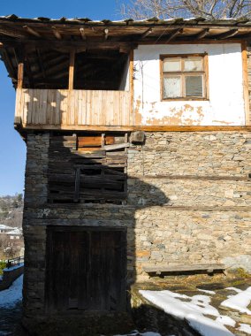 Bulgaristan 'ın Blagoevgrad Bölgesi, Otantik 19. yüzyıl evleriyle Kovaçevitsa Köyü Kış Günbatımı manzarası