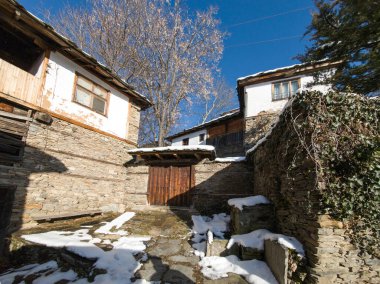 Bulgaristan 'ın Blagoevgrad Bölgesi, Otantik 19. yüzyıl evleriyle Kovaçevitsa Köyü Kış Günbatımı manzarası