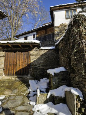 Bulgaristan 'ın Blagoevgrad Bölgesi, Otantik 19. yüzyıl evleriyle Kovaçevitsa Köyü Kış Günbatımı manzarası