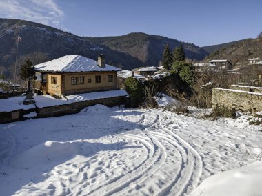Bulgaristan 'ın Blagoevgrad Bölgesi, Otantik 19. yüzyıl evleriyle Kovaçevitsa Köyü Kış Günbatımı manzarası