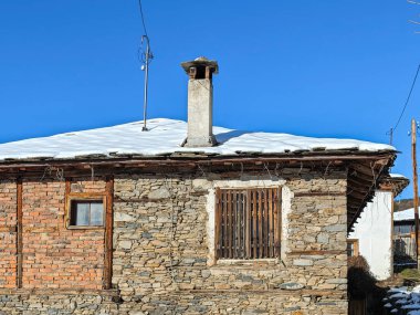 Bulgaristan 'ın Blagoevgrad Bölgesi, Otantik 19. yüzyıl evleriyle Kovaçevitsa Köyü Kış Günbatımı manzarası