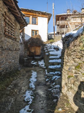 Bulgaristan 'ın Blagoevgrad Bölgesi, Otantik 19. yüzyıl evleriyle Kovaçevitsa Köyü Kış Günbatımı manzarası