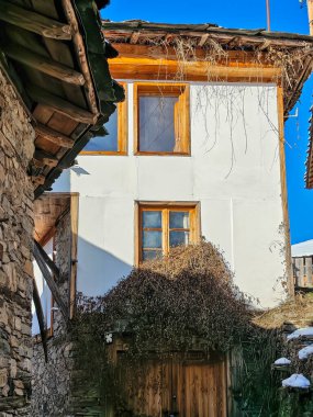 Bulgaristan 'ın Blagoevgrad Bölgesi, Otantik 19. yüzyıl evleriyle Kovaçevitsa Köyü Kış Günbatımı manzarası