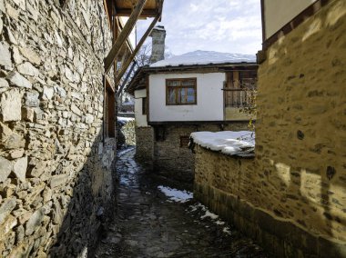 Bulgaristan 'ın Blagoevgrad Bölgesi, Otantik 19. yüzyıl evleriyle Kovaçevitsa Köyü Kış Günbatımı manzarası