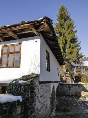Bulgaristan 'ın Blagoevgrad Bölgesi, Otantik 19. yüzyıl evleriyle Kovaçevitsa Köyü Kış Günbatımı manzarası