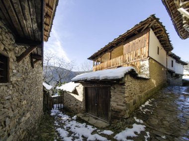 Bulgaristan 'ın Blagoevgrad Bölgesi, Otantik 19. yüzyıl evleriyle Kovaçevitsa Köyü Kış Günbatımı manzarası