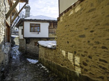 Bulgaristan 'ın Blagoevgrad Bölgesi, Otantik 19. yüzyıl evleriyle Kovaçevitsa Köyü Kış Günbatımı manzarası