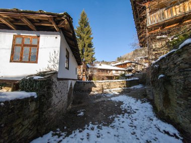 Bulgaristan 'ın Blagoevgrad Bölgesi, Otantik 19. yüzyıl evleriyle Kovaçevitsa Köyü Kış Günbatımı manzarası