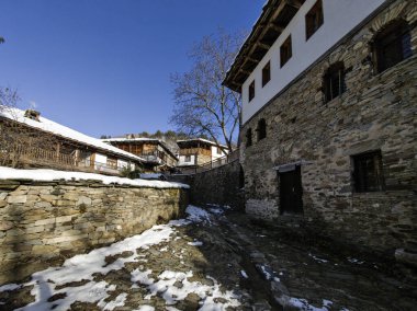 Bulgaristan 'ın Blagoevgrad Bölgesi, Otantik 19. yüzyıl evleriyle Kovaçevitsa Köyü Kış Günbatımı manzarası