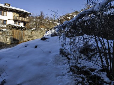 Bulgaristan 'ın Blagoevgrad Bölgesi, Otantik 19. yüzyıl evleriyle Kovaçevitsa Köyü Kış Günbatımı manzarası