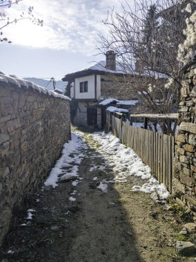 Bulgaristan 'ın Blagoevgrad Bölgesi, Otantik 19. yüzyıl evleriyle Kovaçevitsa Köyü Kış Günbatımı manzarası