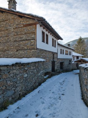 Bulgaristan 'ın Blagoevgrad Bölgesi, Otantik 19. yüzyıl evleriyle Kovaçevitsa Köyü Kış Günbatımı manzarası